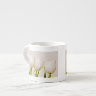 Xícara De Espresso Tulipas brancas contra um fundo branco,
